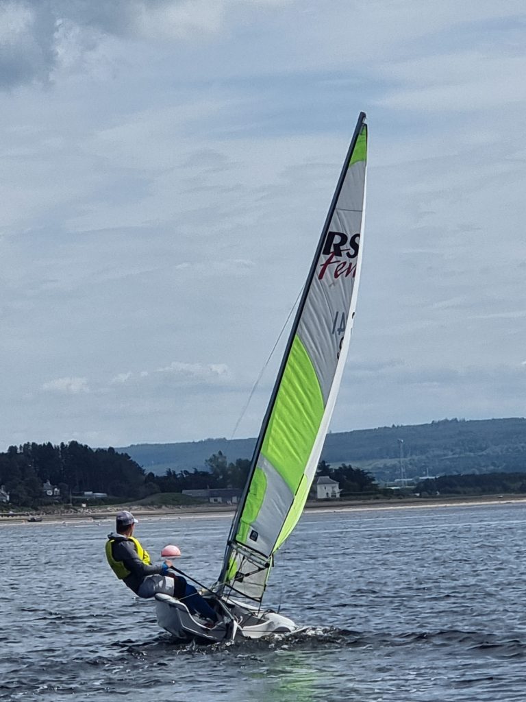 Person sailing small dinghy on coastal waters