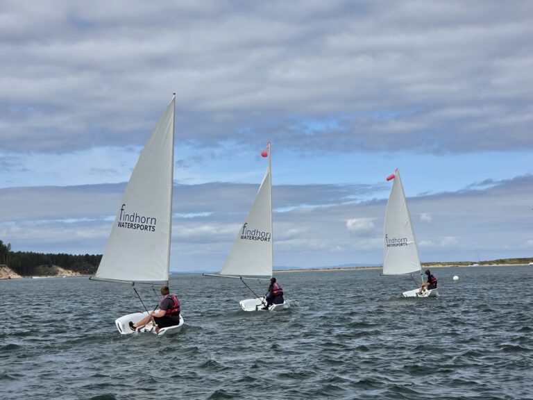 Three dinghies sailing on coastal waters