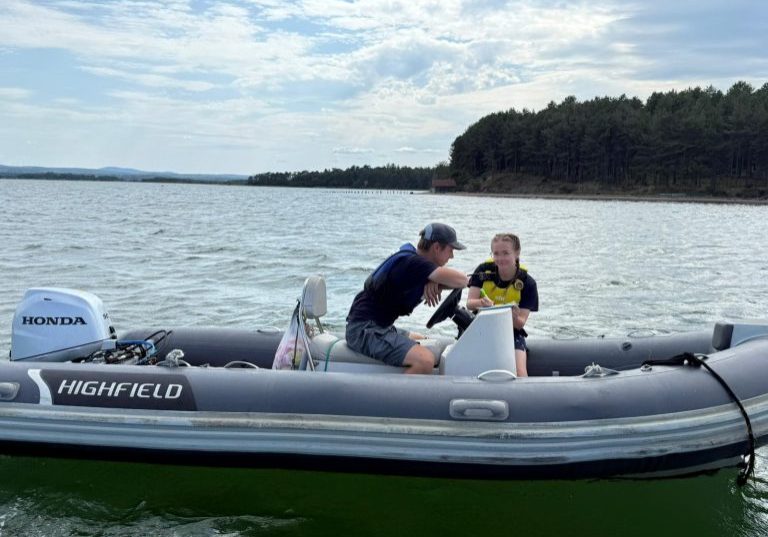 Two people chatting on a Honda Highfield boat