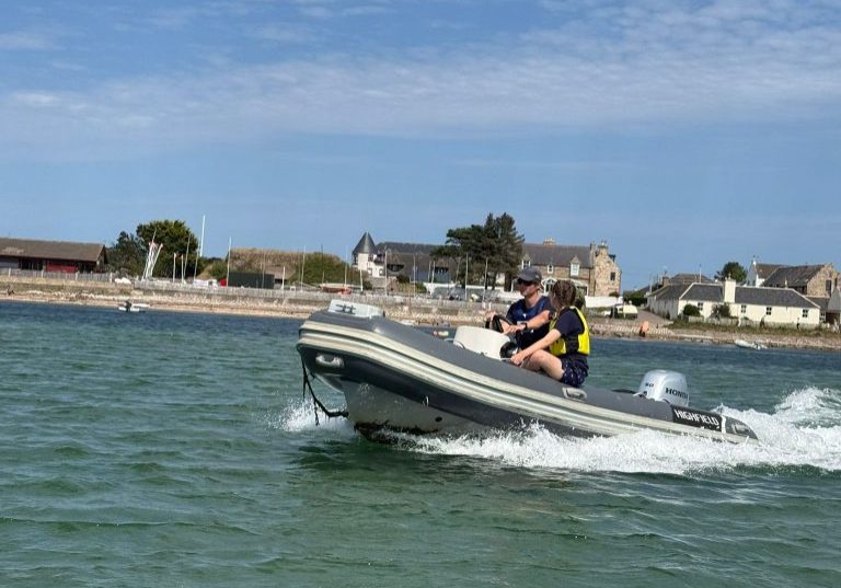 Speedboat navigating vibrant blue waters near coastal town