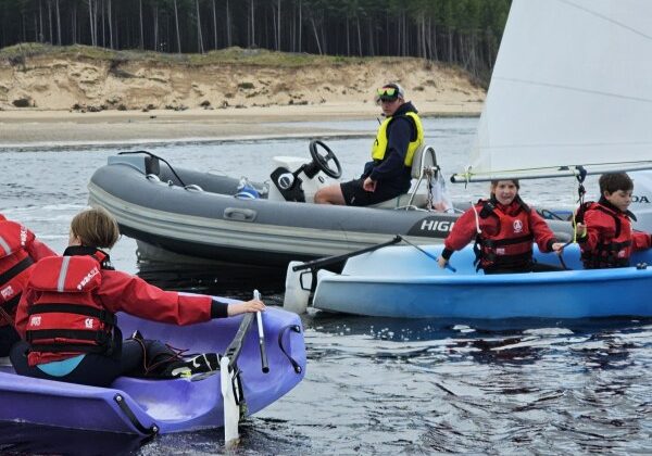 Group sailing and using safety gear on calm sea