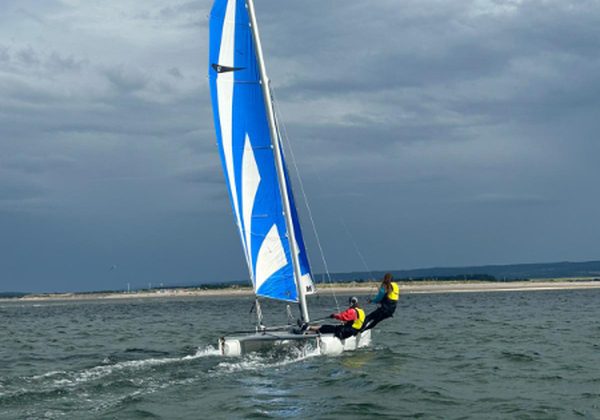 Blue sailboat racing on choppy sea